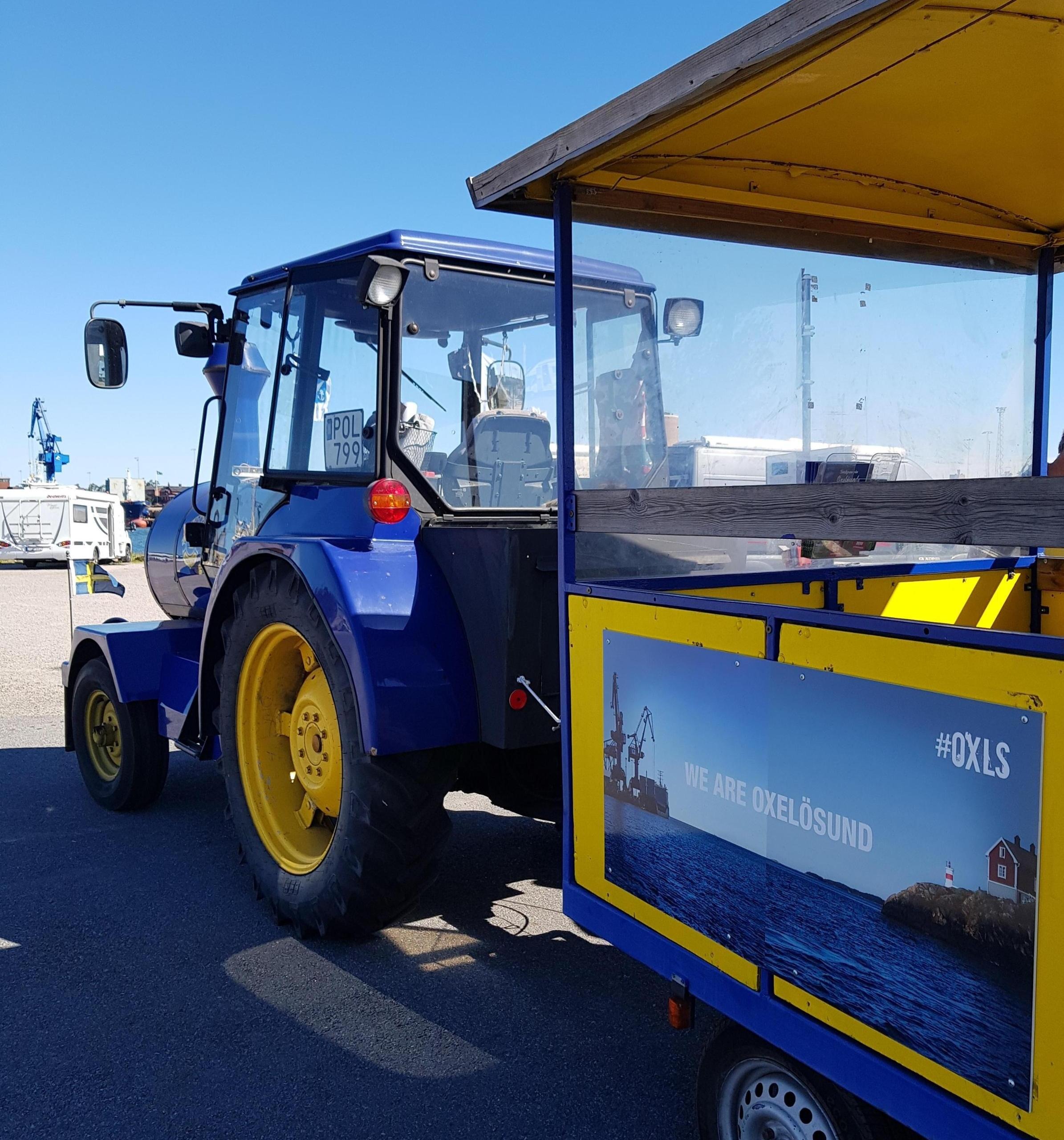 Traktor med bakvagn i färgerna gult och blått