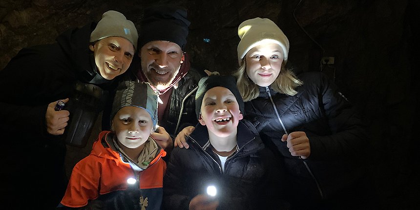 En grupp med vuxna och barn som lyser med ficklampor.