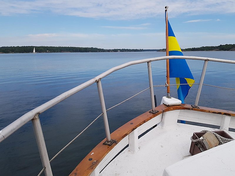 Aktern på en båt med svenska flaggan i Oxelösunds skärgård